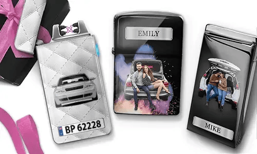 Drei personalisierte Zigarettenetuis sind zu sehen. Das erste zeigt ein Auto mit Kennzeichen. Das zweite zeigt ein Paar, das auf einem Auto sitzt, mit der Aufschrift „Emily“ vor farbenfrohem Hintergrund. Das dritte zeigt ein Paar im Kofferraum eines Autos, mit der Aufschrift „Mike“. Rosafarbene Schleifenakzente sind sichtbar.