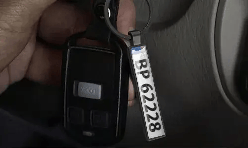 Porte-clés argenté style plaque d’immatriculation suspendu aux clés de voiture