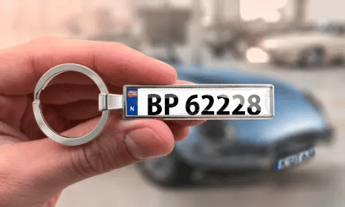 Eochra le pláta uathoibríoch saincheaptha, á shealbhú sa láimh le carr sa chúlra
