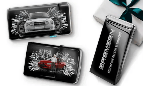 Three sleek black wallets with images of cars and gears, placed near a gift box. 