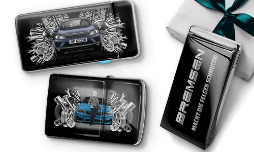 Three automotive-themed items featuring car illustrations and machinery motifs, arranged with a gift box tied with a green ribbon on the side.