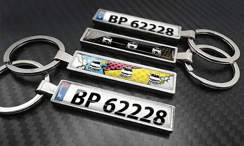 Set aus Comic-Kennzeichen-Schlüsselanhängern mit bunten Autodesigns und Metallfinish