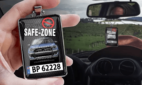 Auto-Safezone-Anhänger mit Carbon Hintergrund und Metallkette in der Hand Safezone-Anhänger