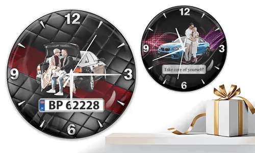 Two wall clocks with family and car scenes: left with trunk picnic on quilted background, right with blue sports car and couple over purple wave