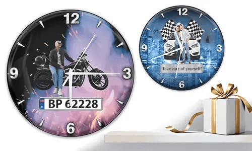 Two wall clocks with vehicle scenes: left with motorcycle and purple-orange glow, right with white cars and racing flags on blue background