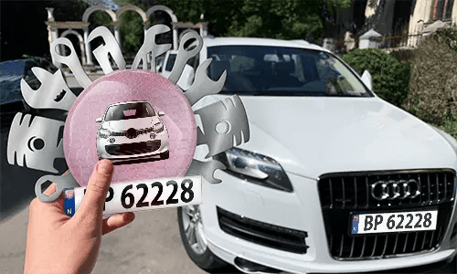 Autoschlüsselanhänger in der Hand mit dem Wagen auf dem Hintergrund individueller schlüsselanhänger